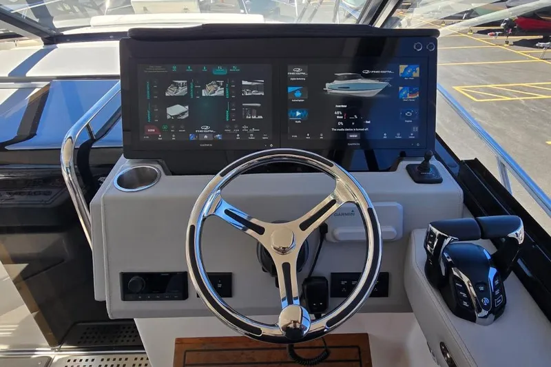 Slide: The Image of 2024 Regal 36 XO yacht helm with advanced Garmin navigation system and sleek steering wheel. - 38