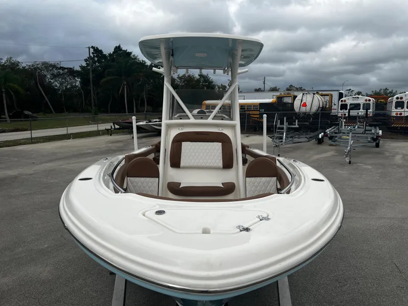 Slide: The Image of 2024 Pioneer 202 Islander boat with white and brown seating, parked on a lot. - 11