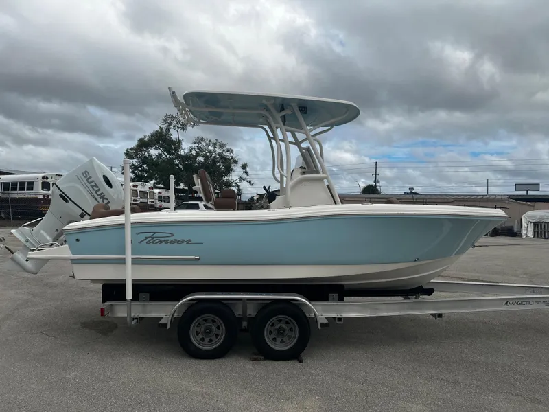 Slide: The Image of 2024 Pioneer 202 Islander boat on trailer, side view, light blue hull, Suzuki outboard motor. - 4