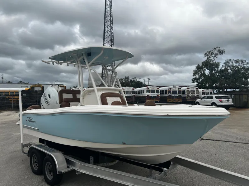 Slide: The Image of 2024 Pioneer 202 Islander boat on trailer, light blue hull, overcast sky background. - 5
