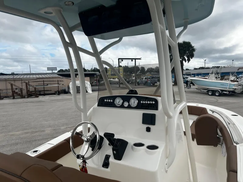 Slide: The Image of 2024 Pioneer 202 Islander boat dashboard and controls at a marina. - 6