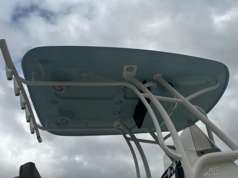 Slide: The Image of 2024 Pioneer 202 Islander boat with blue T-top against cloudy sky. - 7