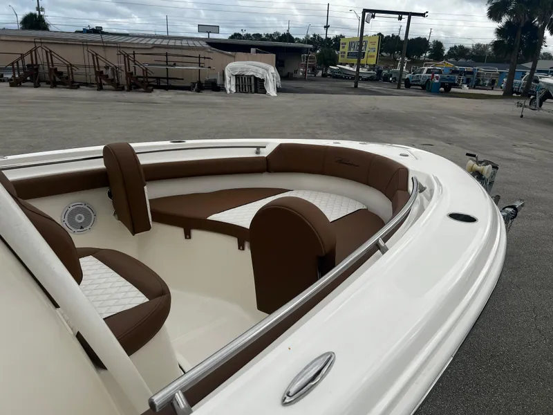 Slide: The Image of 2024 Pioneer 202 Islander boat with brown and white seating in a marina. - 8