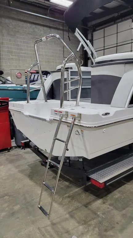 Slide: The Image of 2024 Hurricane Fundeck 2360 SBC OB boat with rear ladder in a warehouse. - 5