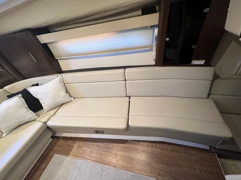 Slide: The Image of Interior seating area of a 2017 Regal 35 Sport Coupe with beige cushions and striped pillows. - 16