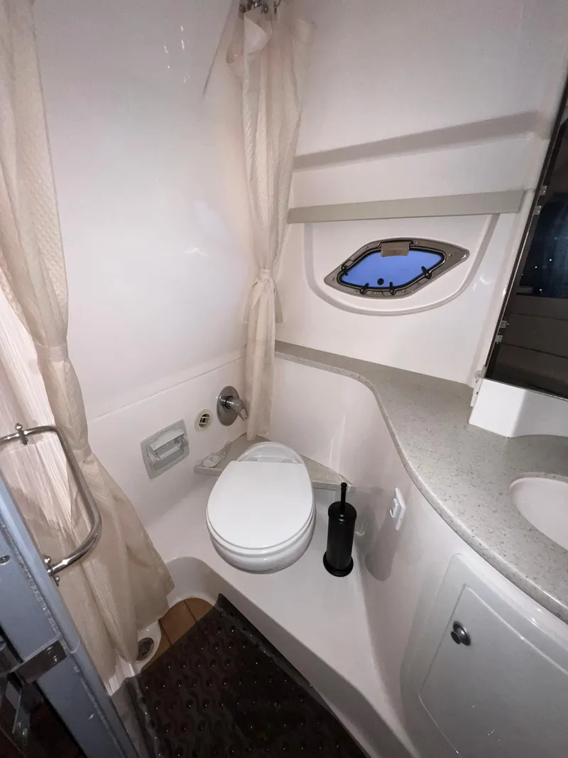 Slide: The Image of 2017 Regal 35 Sport Coupe bathroom with toilet, sink, and porthole window. - 21
