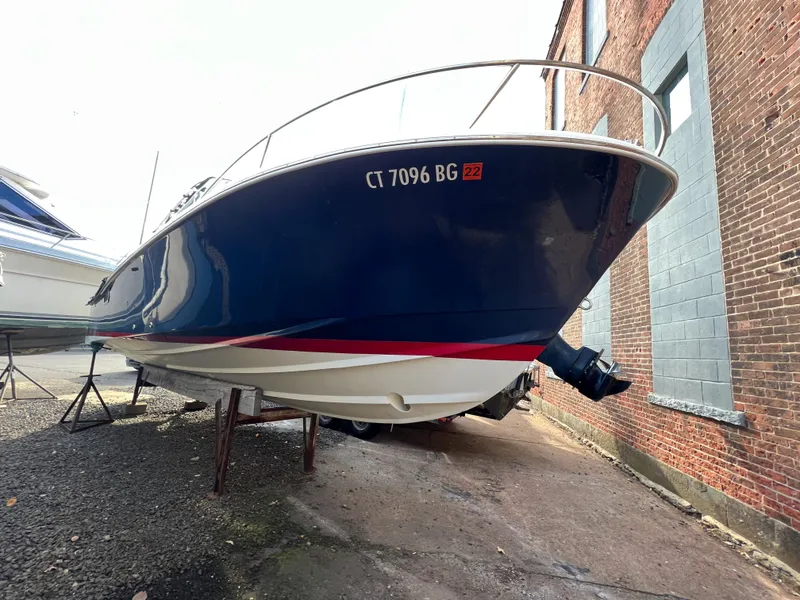 Slide: The Image of 2015 Hunt Yachts Harrier Sport boat on dry dock, blue hull with red stripe. - 15