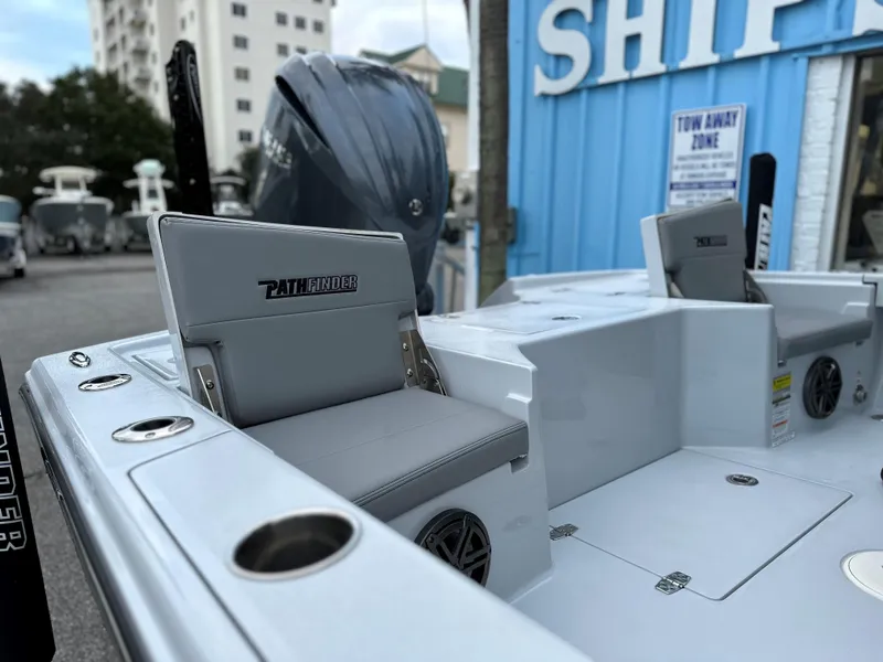 Slide: The Image of 2024 Pathfinder 2500 Hybrid boat interior with seating and motor, docked near a blue building. - 10