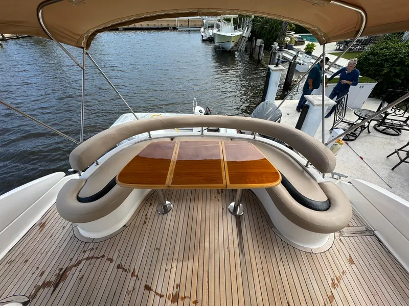 Slide: The Image of Luxury 2006 Neptunus 55 Cabrio yacht with elegant outdoor seating and wooden table. - 14