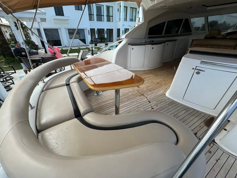 Slide: The Image of Luxurious 2006 Neptunus 55 Cabrio yacht interior with curved seating and wooden table. - 17