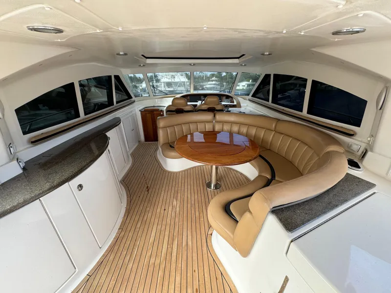 Slide: The Image of Interior of 2006 Neptunus 55 Cabrio yacht with curved seating and wooden table. - 22