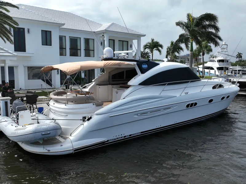 Slide: The Image of 2006 Neptunus 55 Cabrio yacht docked near a waterfront home. - 4