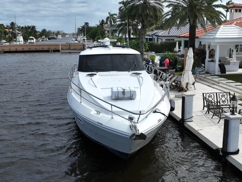 Slide: The Image of 2006 Neptunus 55 Cabrio yacht docked by a waterfront home with palm trees. - 5