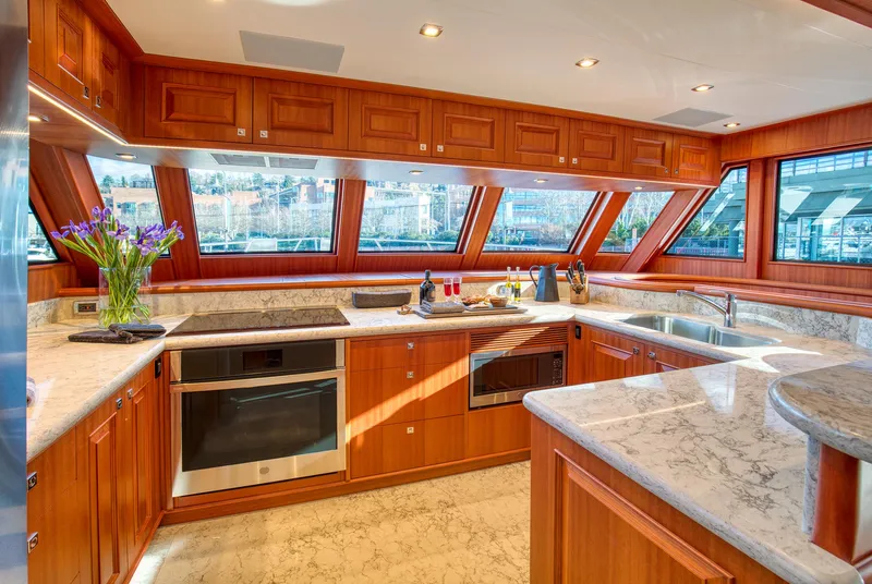 Slide: The Image of Luxurious kitchen interior of 2025 Hampton 750 Endurance LRC yacht with wood cabinetry and marble countertops. - 25