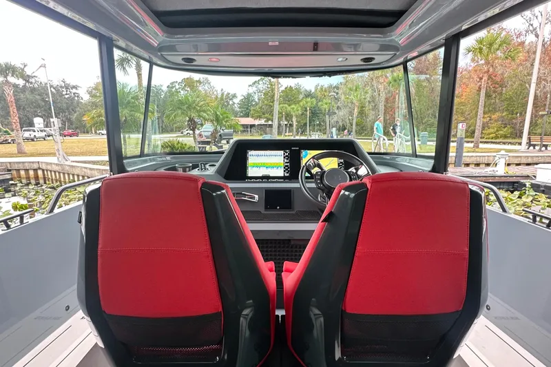 Slide: The Image of Das Bild zeigt das Cockpit eines Axopar Brabus Shadow 500 T-Top von 2022 mit roten Sitzen. - 12