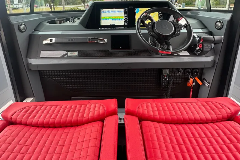 Slide: The Image of Das Cockpit der Axopar Brabus Shadow 500 T-Top von 2022 zeigt rote Sitze und ein modernes Armaturenbrett. - 16