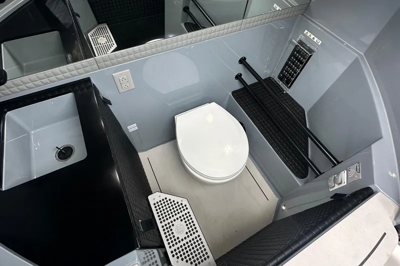 Slide: The Image of Das Bild zeigt ein modernes Badezimmer auf einem Boot mit Toilette, Waschbecken und Spiegel. - 23