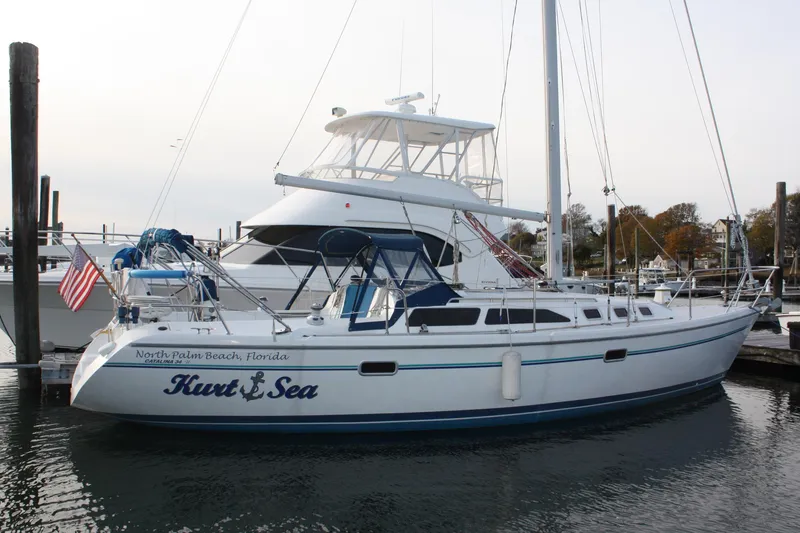 Slide: The Image of 1996 Catalina 34 MkII sailboat docked in a marina, displaying an American flag. - 1