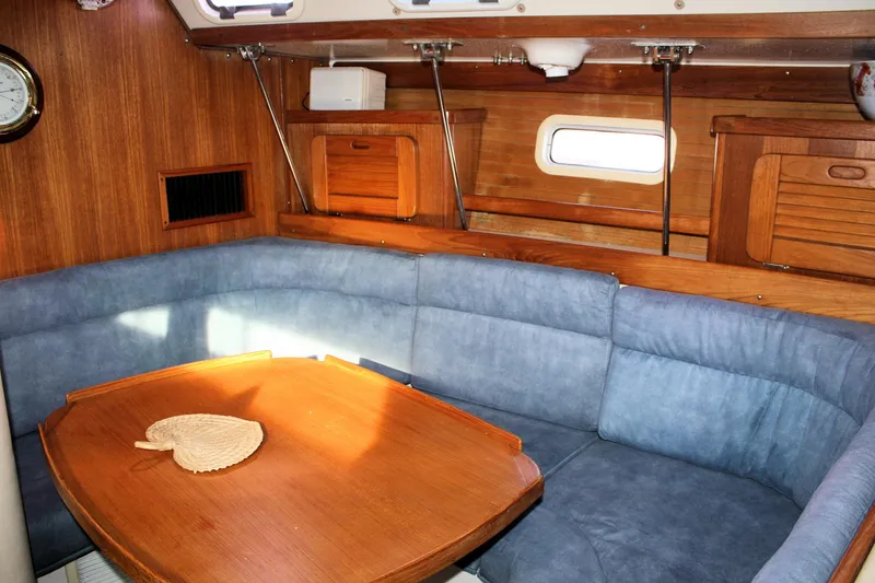 Slide: The Image of Interior of 1996 Catalina 34 MkII sailboat with blue seating and wooden table. - 22