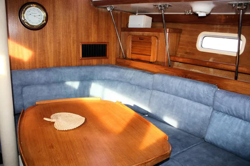 Slide: The Image of Interior of 1996 Catalina 34 MkII sailboat with blue seating and wooden table. - 24