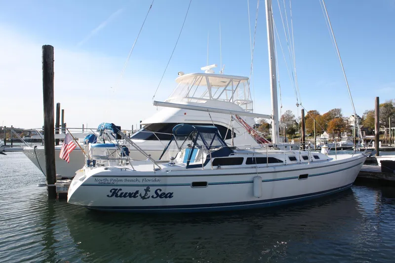Slide: The Image of 1996 Catalina 34 MkII sailboat docked in a marina, featuring a sleek white design. - 7