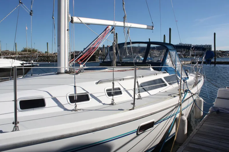 Slide: The Image of 1996 Catalina 34 MkII sailboat docked in a marina, featuring sleek design and spacious deck. - 8
