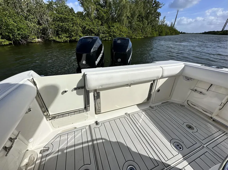 Slide: The Image of 2014 Boston Whaler 280 Outrage boat with twin outboard engines on a calm waterway. - 10