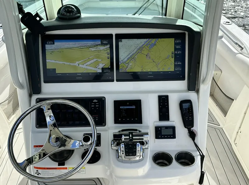 Slide: The Image of 2014 Boston Whaler 280 Outrage helm with dual navigation screens and controls. - 16