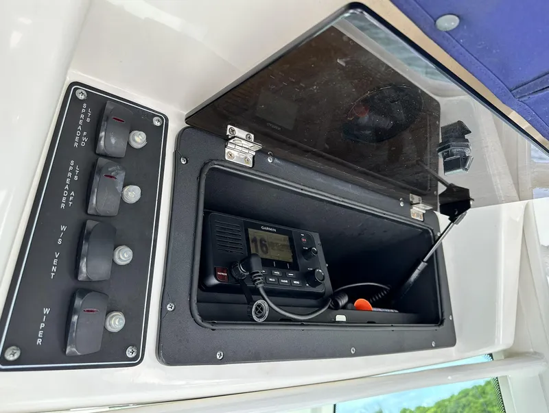 Slide: The Image of Control panel and radio compartment on a 2014 Boston Whaler 280 Outrage boat. - 17