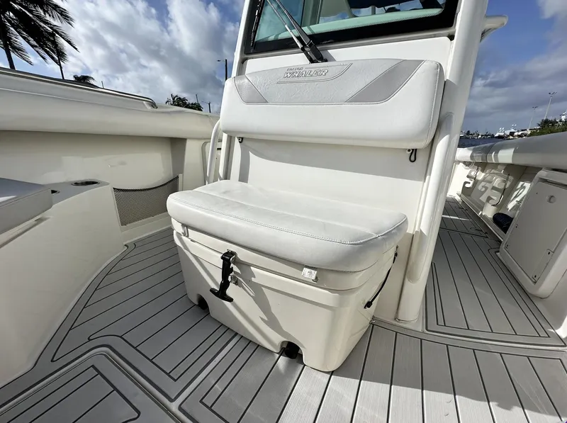 Slide: The Image of 2014 Boston Whaler 280 Outrage boat interior with cushioned seating and storage. - 19