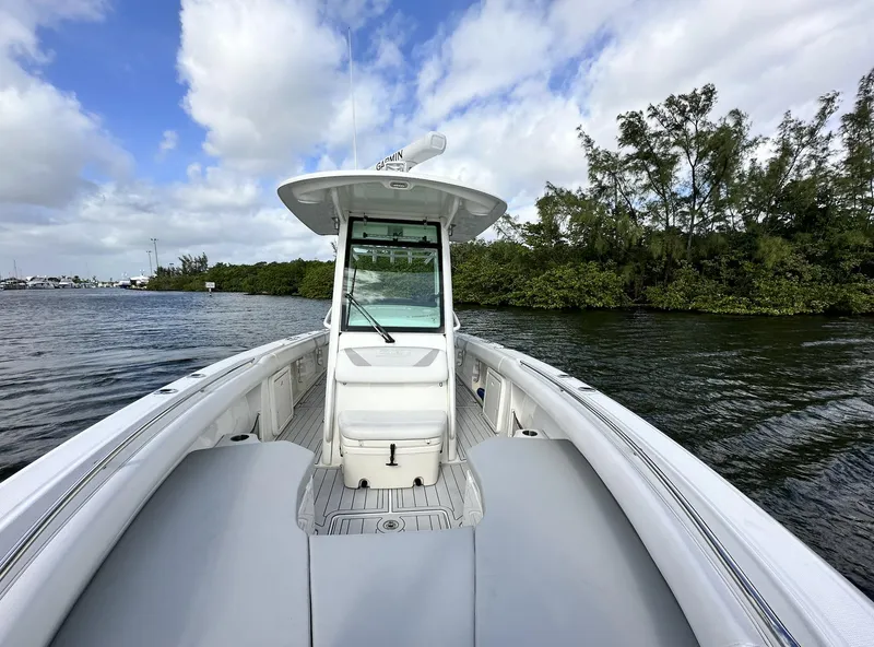 Slide: The Image of 2014 Boston Whaler 280 Outrage boat on calm water with lush greenery in the background. - 24