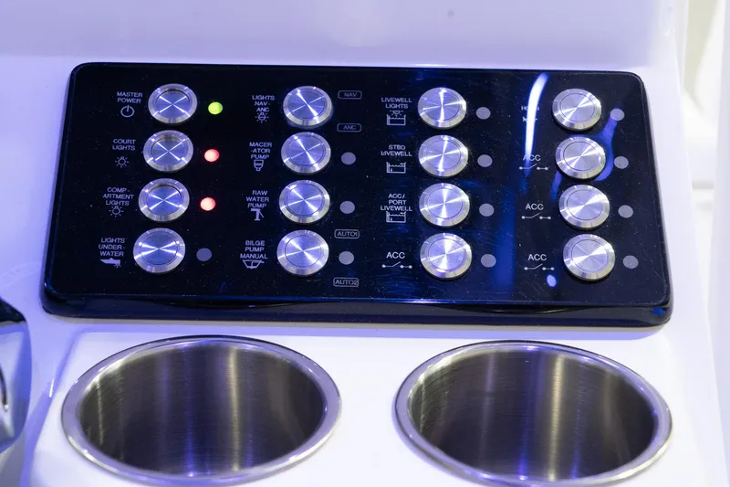 Slide: The Image of Control panel of 2024 Caymas 281 HB boat with illuminated buttons and cup holders. - 14