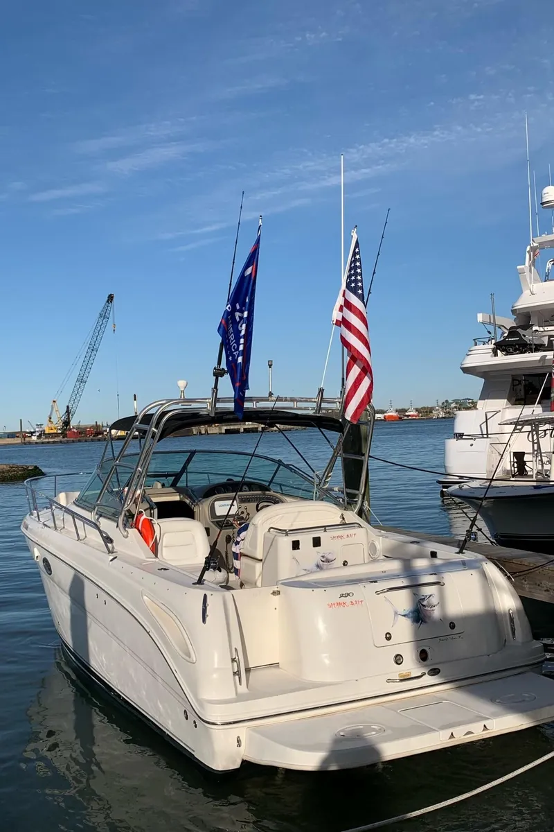 Slide: The Image of 2006 Sea Ray 290 Amberjack boat docked at marina with flags. - 12