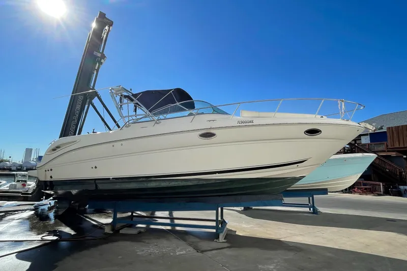 Slide: The Image of 2006 Sea Ray 290 Amberjack boat on a lift under clear blue sky. - 13