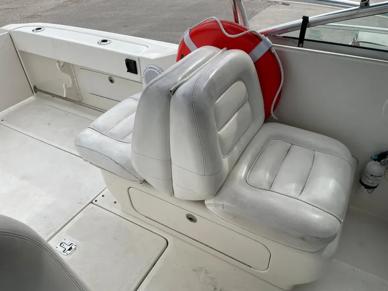 Slide: The Image of 2006 Sea Ray 290 Amberjack boat interior with white leather seats and life preserver. - 23