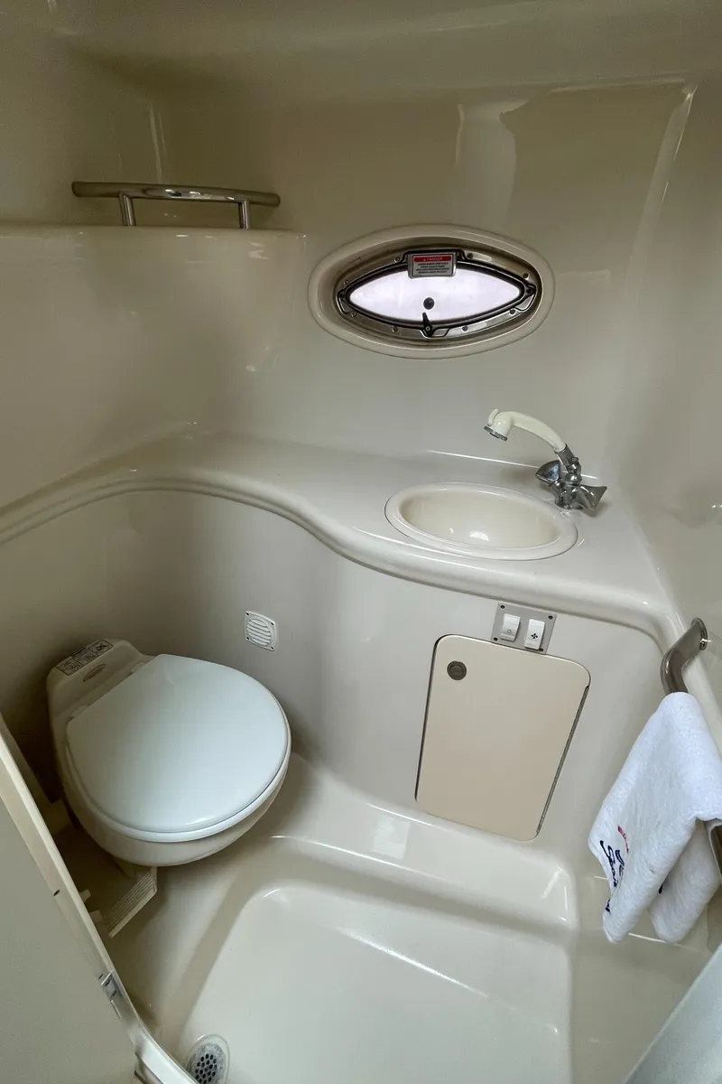Slide: The Image of 2006 Sea Ray 290 Amberjack bathroom with sink, toilet, and porthole window. - 27