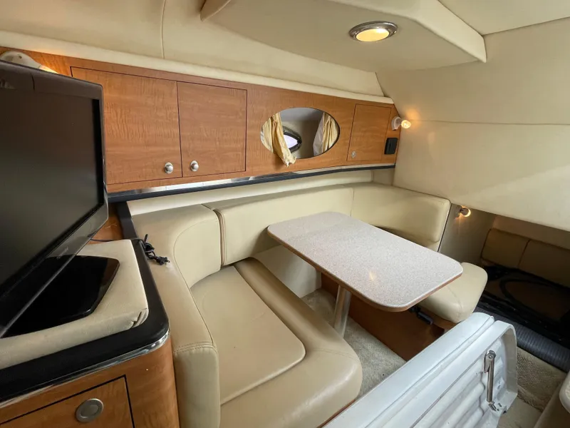Slide: The Image of Interior of 2006 Sea Ray 290 Amberjack with beige seating and wooden cabinetry. - 29