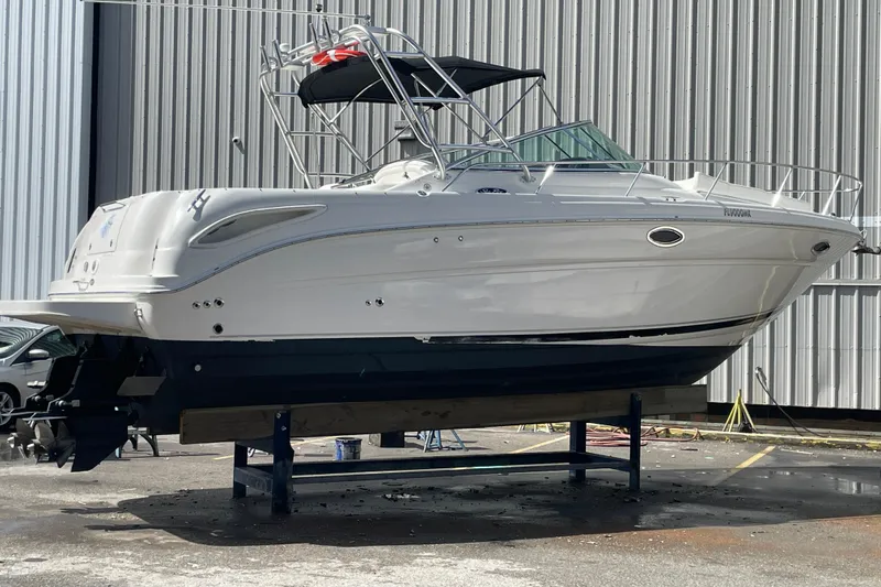 Slide: The Image of 2006 Sea Ray 290 Amberjack boat on stand, side view, near industrial building. - 44