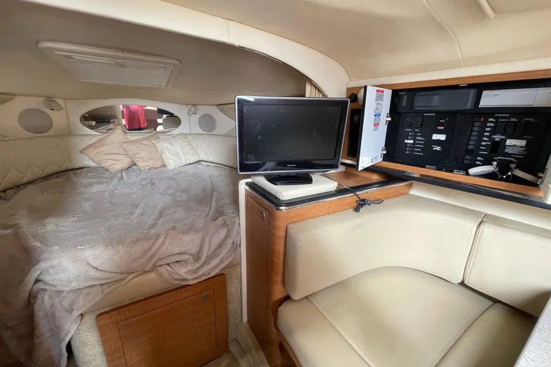 Slide: The Image of 2006 Sea Ray 290 Amberjack cabin interior with bed, TV, and control panel. - 49