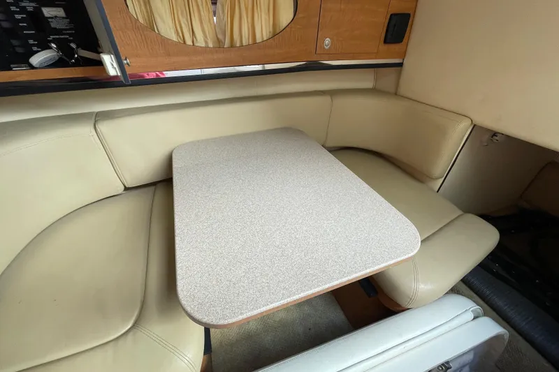 Slide: The Image of 2006 Sea Ray 290 Amberjack cabin with beige seating and table. - 52