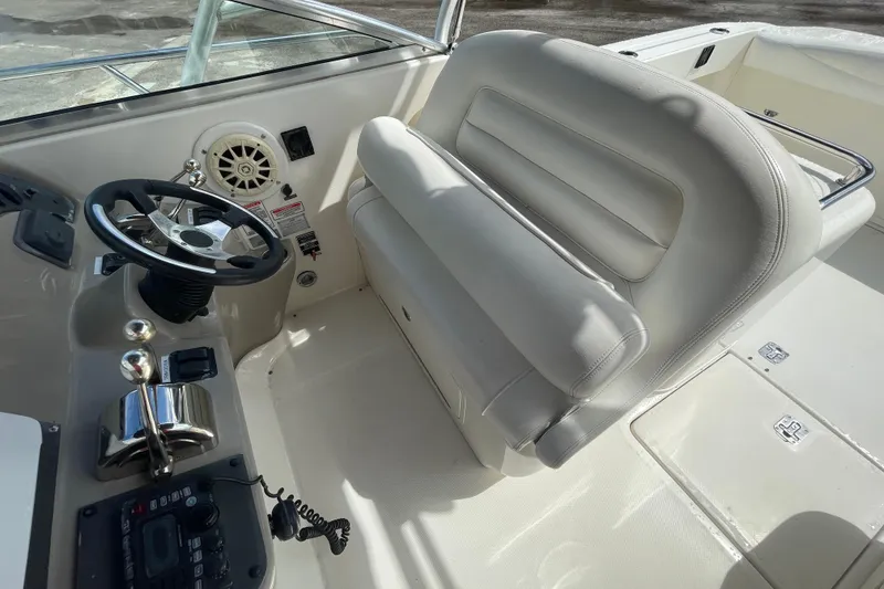 Slide: The Image of 2006 Sea Ray 290 Amberjack helm with steering wheel, controls, and cushioned seating. - 61