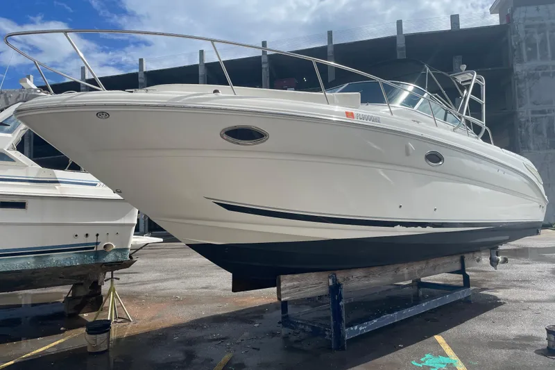 Slide: The Image of 2006 Sea Ray 290 Amberjack boat on dry dock, side view under clear sky. - 65