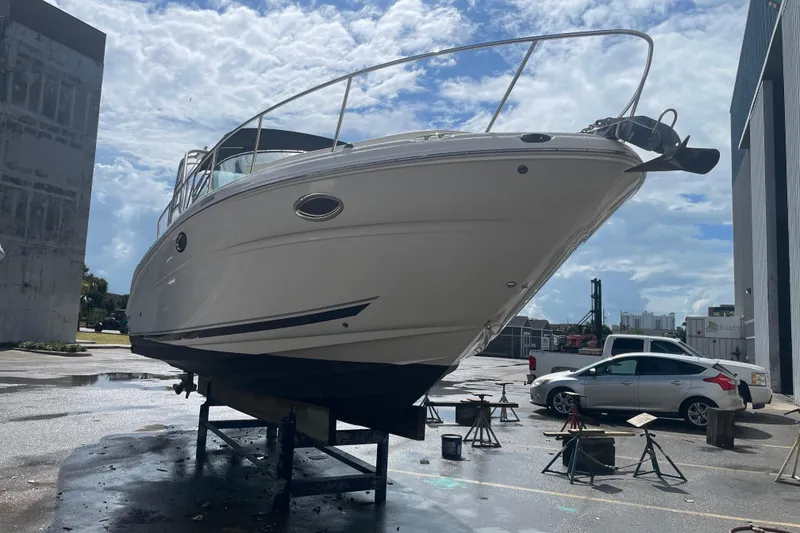 Slide: The Image of 2006 Sea Ray 290 Amberjack boat on dry dock under a partly cloudy sky. - 66
