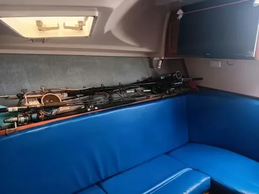 Slide: The Image of Interior of 1995 Luhrs 32 Tournament Open with fishing rods and blue seating. - 10