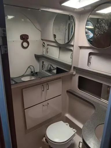 Slide: The Image of 1995 Luhrs 32 Tournament Open boat bathroom with sink, toilet, and storage. - 11