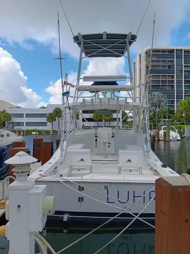 Slide: The Image of 1995 Luhrs 32 Tournament Open boat docked at marina with buildings in background. - 3