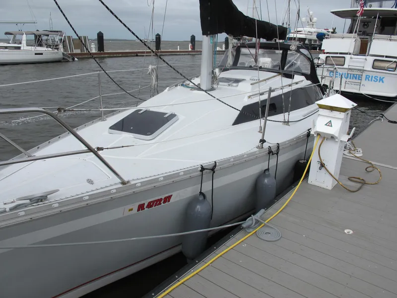 The Image of 1987 O'Day 322 sailboat docked at marina with fenders and power hookup. - 0