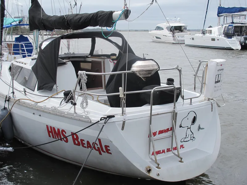 Slide: The Image of 1987 O'Day 322 sailboat HMS Beagle docked, featuring Snoopy graphic on stern. - 10