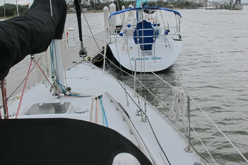 Slide: The Image of 1987 O'Day 322 sailboat docked near another sailboat on a calm waterway. - 15
