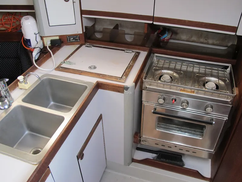 Slide: The Image of 1987 O'Day 322 sailboat galley with stove, sink, and storage. - 24